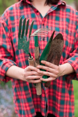 Woman holding selection of gardening tools