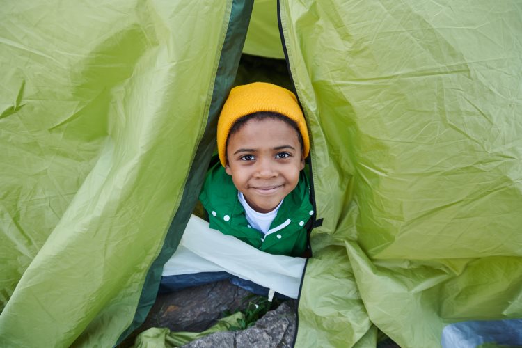 Child looking out of tent
